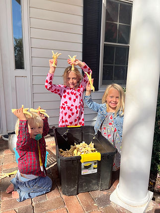 Three kids playing with chicken feet. 