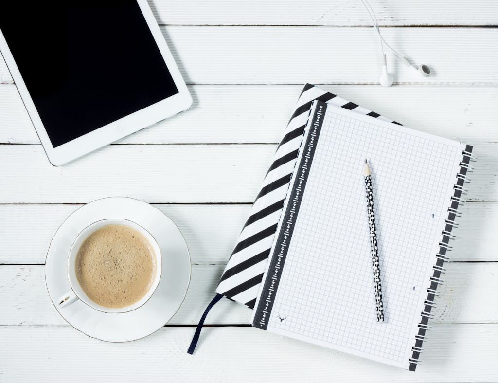 White Tablet Computer Beside White Notebook