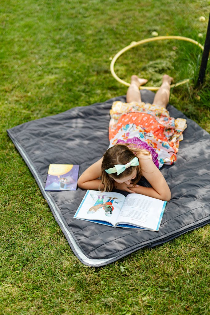 Girl Lying on Grass and Reading Book 
