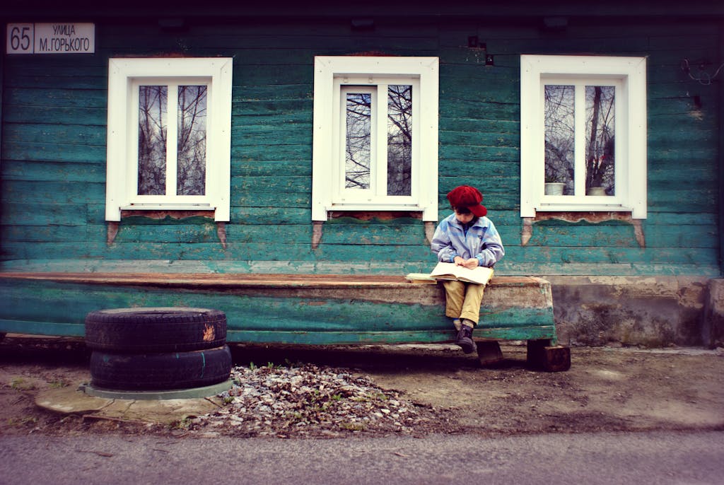 Boy Reading On Bench