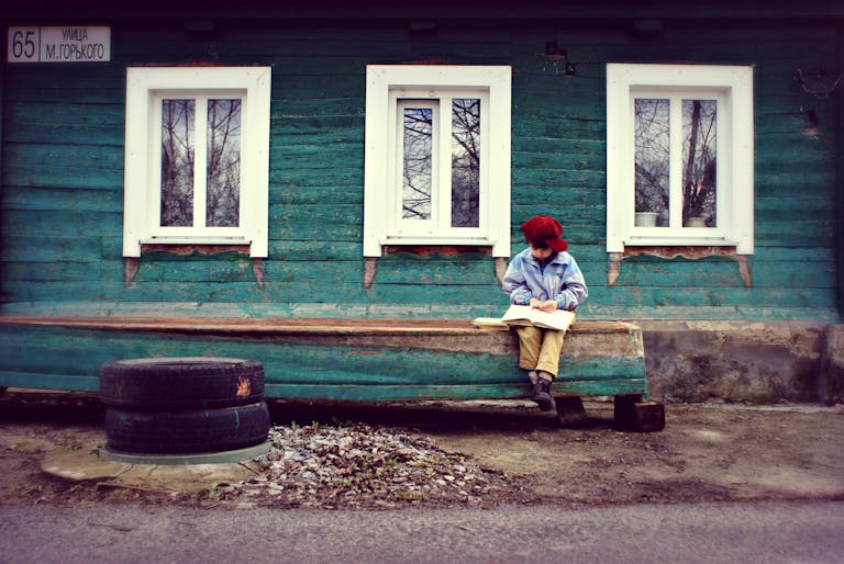 Boy Reading On Bench